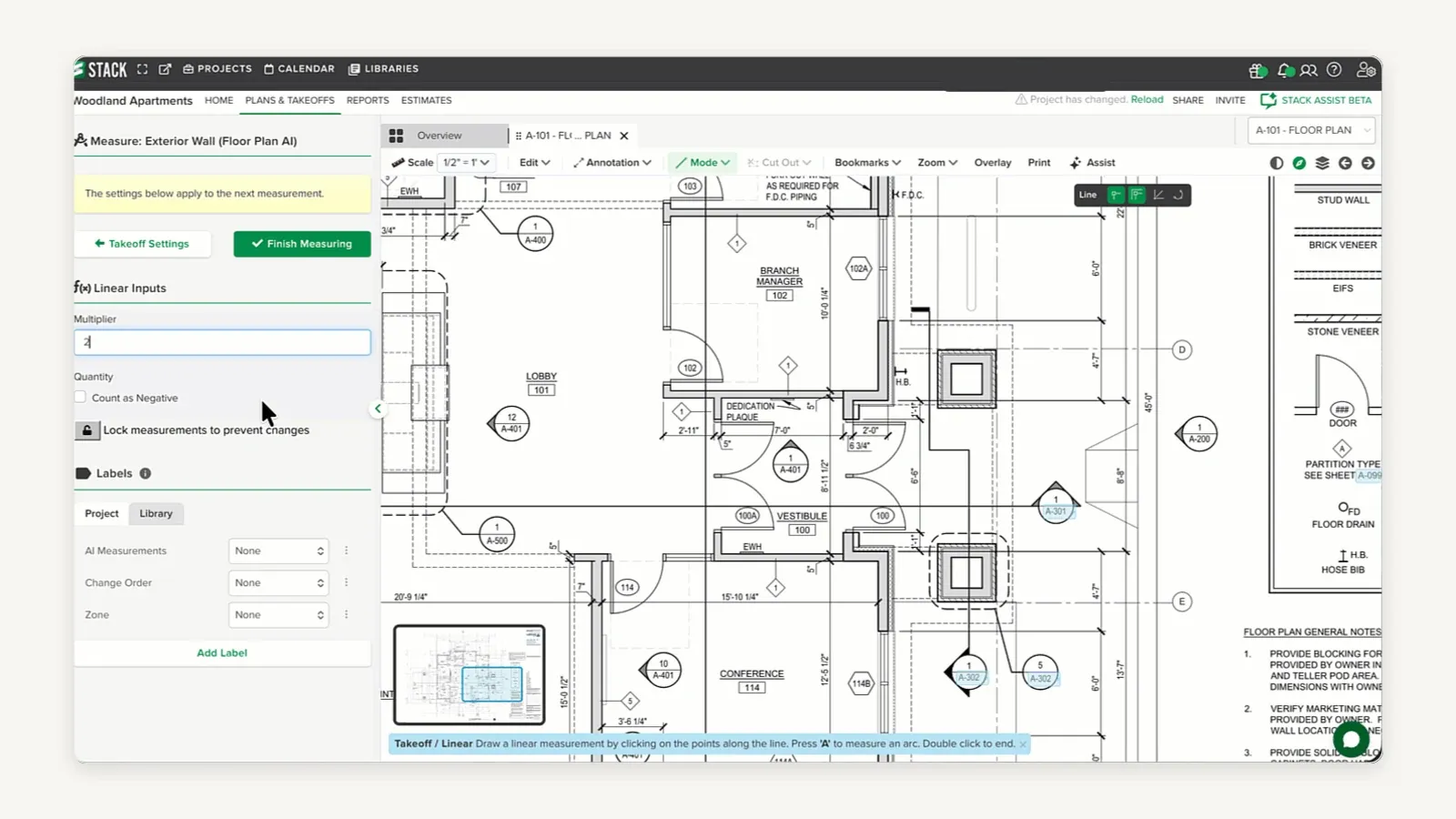 STACK's Plans and Takeoffs screen on a project named Woodland Apartments, with sheet tab A-101 Floor Plan open at a scale of 1/2 inch = 1 foot. A construction drawing fills most of the frame, rooms labelled Lobby 101, Branch Manager 102, Vestibule 100, Dedication Plaque and Conference 114, with dimension strings, door tags and a keynote column reading Stud Wall, Brick Veneer, EIFS, Stone Veneer, Door, Partition Type, Floor Drain and Hose Bib. A left panel headed Measure: Exterior Wall (Floor Plan AI) carries Takeoff Settings and Finish Measuring buttons, a Linear Inputs multiplier field, a Count as Negative checkbox, a lock for measurements, and label pickers for AI Measurements, Change Order and Zone, each set to None. A prompt across the bottom reads Takeoff / Linear — draw a linear measurement by clicking on the points along the line.